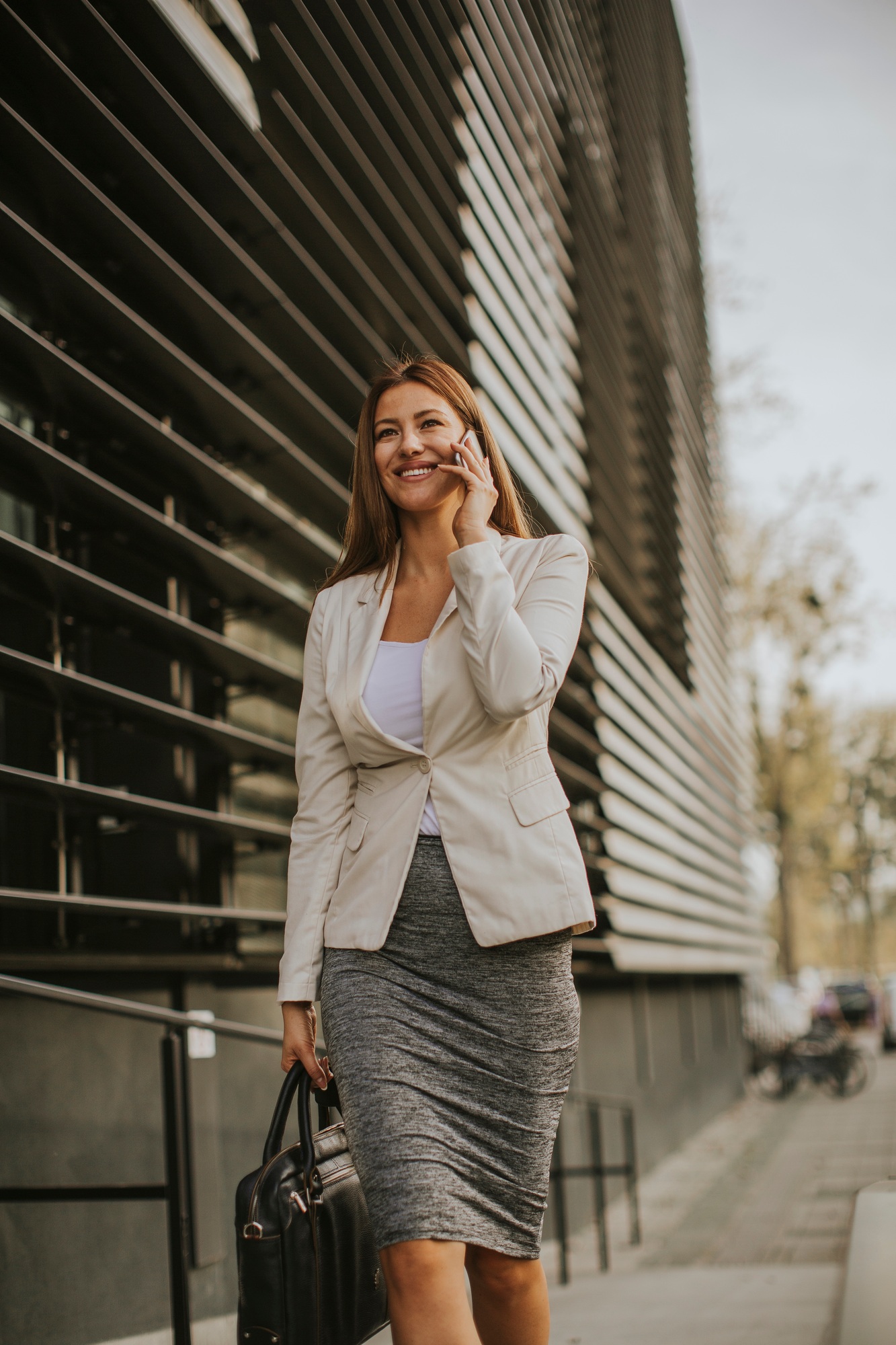 Businesswoman talking on the phone near office building