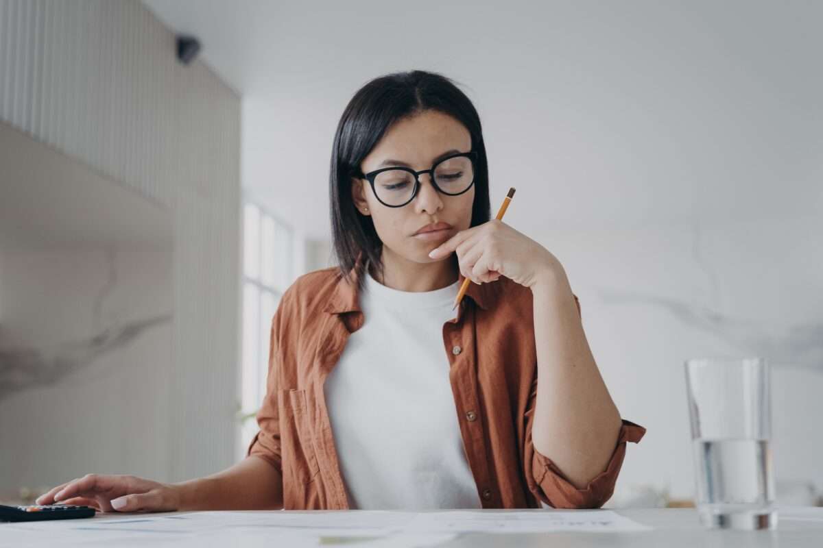 10 Ways DIY Websites Sabotage Small Businesses (And How to Avoid It) 10 Female housewife in glasses calculates expenses, planning household budget for saving money at home