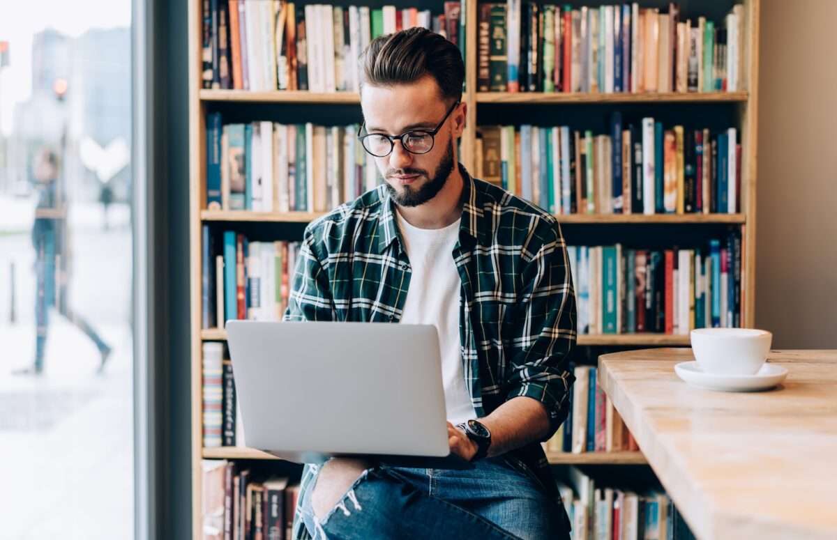 Beyond the Basics: 5 Advanced SEO Tips to Increase Web Traffic 5 Hipster guy in spectacles searching education information via netbook in library