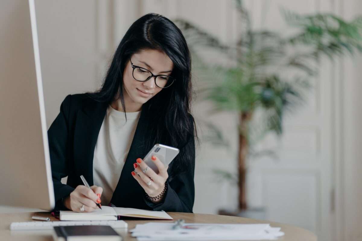 Beyond the Basics: 5 Advanced SEO Tips to Increase Web Traffic 1 Woman with dark hair, concentrated into mobile phone, searches necessary information in internet