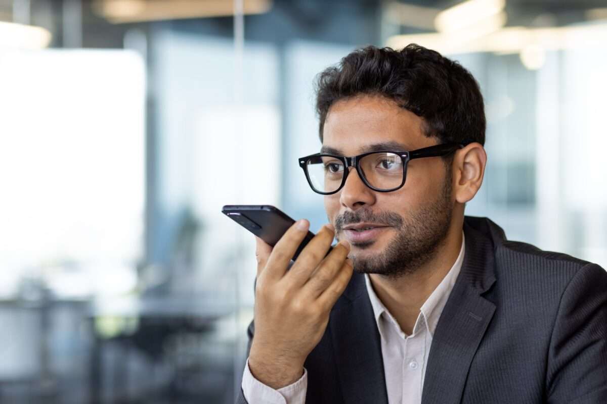 A man inside the office writes down the main message using an application on the phone, a smiling