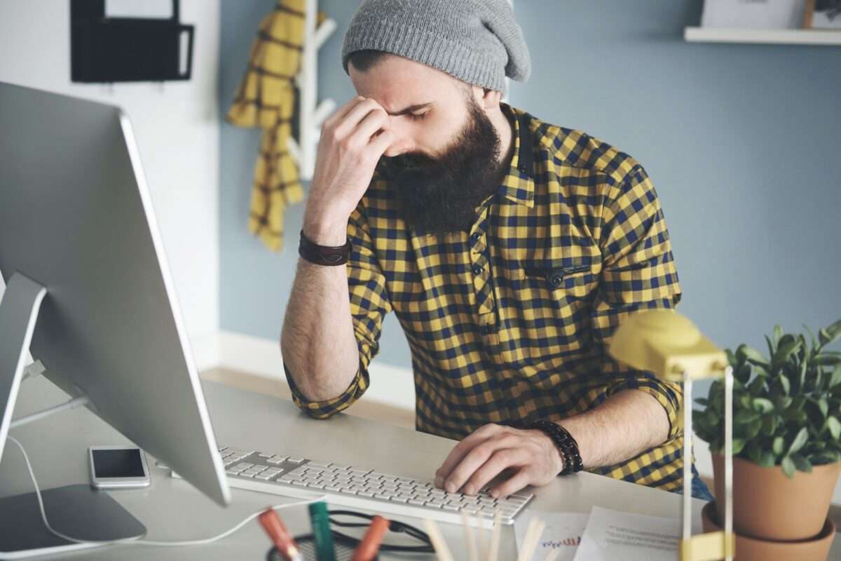 Frustrated young man at computer desk